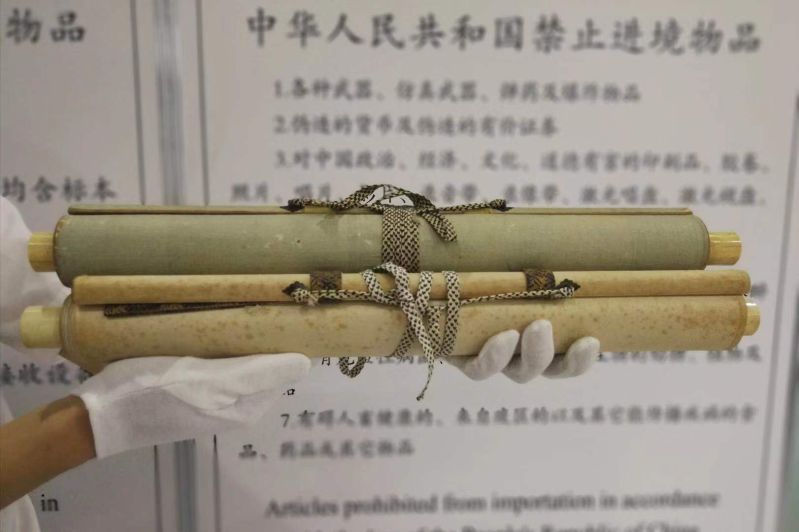 图为：青岛流亭机场海关查获的镶嵌有象牙的字画卷轴