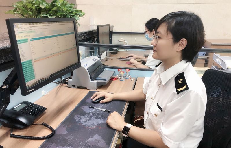 图为：海关关员查看智能审核回执   王路摄
