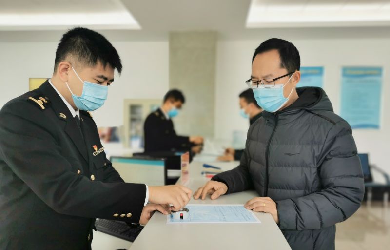 图为：海关关员为企业办理原产地签证手续+贾秀平